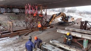 Pracownicy oraz ciężki sprzęt podczas budowy podpór 