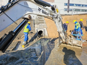 Pracownicy i koparka podczas pracy
