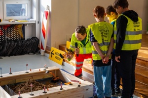 Prowadzący uczy obsługi maszyn na miniplacu budowy