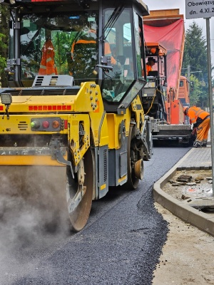 układanie masy bitumicznej na ul. Radosnej, widok na sprzęt budowlany 