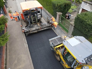 układanie masy bitumicznej na ul. Radosnej, widok na sprzęt budowlany 