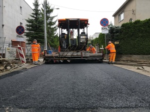 układanie masy bitumicznej na ul. Radosnej, widok na sprzęt budowlany 