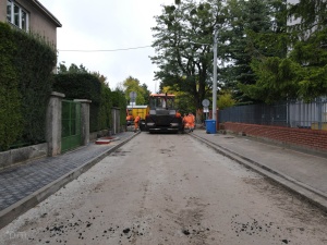 układanie masy bitumicznej na ul. Radosnej, widok na sprzęt budowlany 