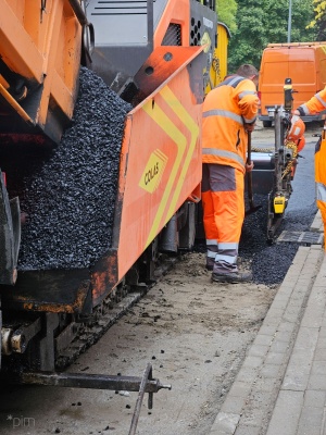 układanie masy bitumicznej na ul. Radosnej, widok na sprzęt budowlany 