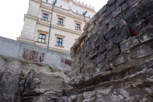 fragment murów fundamentowych na tle ratusza