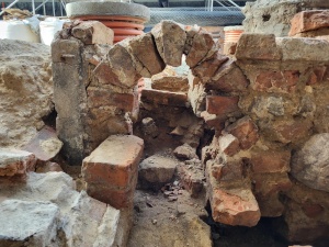 Fragmenty murów i fundamentów średniowiecznych kamienic kupieckich na ul. Jana Baptysty Quadro