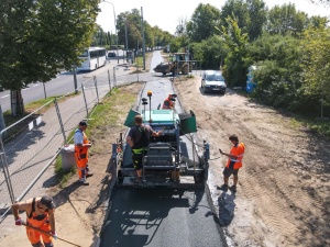 Rozściełacz oraz pracownicy podczas wykonywania prac nawierzchniowych